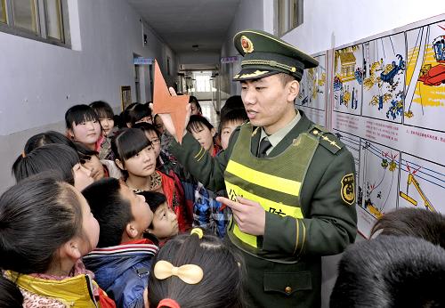 3月23日,唐山市澗河邊防派出所的民警劉育才為畢家圈小學(xué)學(xué)生講解安全用電常識。當(dāng)日,河北省唐山市澗河邊防派出所民警來到轄區(qū)內(nèi)的畢家圈小學(xué),組織小學(xué)生進(jìn)行逃生自救和疏散演練,進(jìn)行安全知識講解,提高小學(xué)生安全自救和避險能力,迎接即將到來的第17個全國中小學(xué)生安全教育日。新華社記者 楊世堯 攝