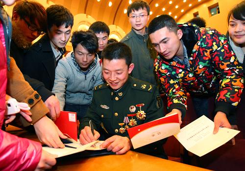 3月23日,報(bào)告會(huì)結(jié)束后大學(xué)生們爭(zhēng)相請(qǐng)現(xiàn)任“雷鋒班”班長(zhǎng)黃幫維簽名留念。新華社記者 査春明 攝