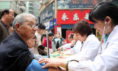 4月6日,參與“愛(ài)心義診”的醫(yī)務(wù)人員為重慶市永川區(qū)昌州路社區(qū)居民測(cè)量血壓。新華社發(fā)(陳仕川 攝)