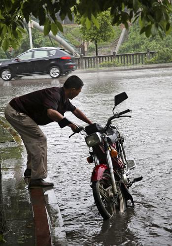 5月9日,湖南省婁底市遭遇強(qiáng)降雨天氣,一輛摩托車在道路積水中熄火。新華社發(fā)