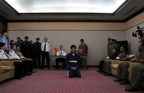 5月10日,在老撾萬象的瓦岱國際機(jī)場,日前被中老警方聯(lián)手抓獲的湄公河流域“金三角”地區(qū)特大武裝販毒集團(tuán)首犯糯康(前中)被正式依法移交給中國警方,乘中方派出的包機(jī)押解到中國。新華社發(fā)(塔納克儂攝)