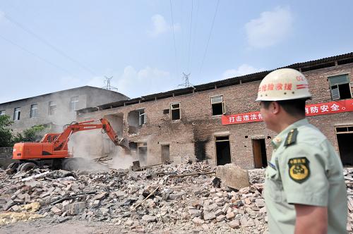5月10日,一名消防部隊干部指揮挖掘機依法拆除重慶市渝北區(qū)回興街道長河村的一處消防違法建筑。新華社記者 劉潺 攝