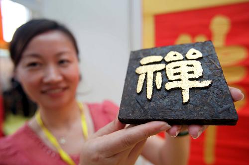 5月11日,在第二屆中國國際茶業(yè)及茶藝博覽會上,工作人員展示帶有“禪”字的普洱茶。新華社發(fā)
