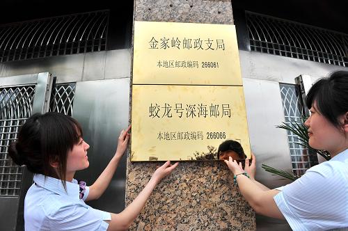 6月3日,山東青島郵政工作人員在為“蛟龍?zhí)?#8221;深海郵局的地面郵局掛牌。我國載人深潛7000米級海試3日正式起航之際,中國郵政集團公司在起航儀式現場宣布成立“蛟龍?zhí)?#8221;深海郵局。郵局設在位于海底7000米處的“蛟龍?zhí)?#8221;載人深潛器艙體內,目前主要開辦國際國內函件寄遞和集郵業(yè)務,郵政編碼為266066。深海郵局的地面郵局設在青島市嶗山區(qū)的金家?guī)X郵政支局,3日同時掛牌開業(yè),用戶即可前往辦理業(yè)務。新華社發(fā)(崔鵬森 攝)