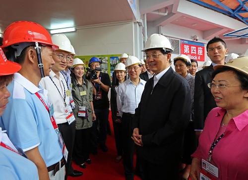 6月30日,國家主席胡錦濤在香港考察啟德發(fā)展計劃。這是胡錦濤在公共房屋建設(shè)工地同工程師和工人代表親切交談。新華社發(fā)