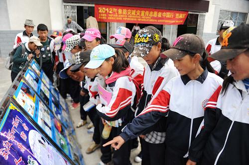 7月10日,西藏林周縣中學(xué)的學(xué)生在觀看氣象防災(zāi)減災(zāi)知識展板。當(dāng)日,“2012年氣象防災(zāi)減災(zāi)宣傳志愿者中國行·在西藏”科普活動在拉薩啟動,包括蘭州大學(xué)在內(nèi)的3所高校的34名在校大學(xué)生志愿者奔赴西藏各地開展科普知識宣傳。新華社記者 文濤 攝