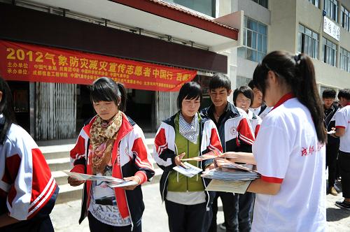 7月10日,大學(xué)生志愿者在西藏林周縣中學(xué)向?qū)W生們發(fā)放氣象防災(zāi)減災(zāi)宣傳資料。新華社記者 文濤 攝