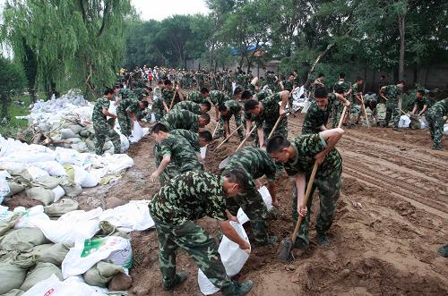 7月25日,武警北京總隊(duì)某部官兵在京港澳高速南崗?fù)莸囟蝺蓚?cè)進(jìn)行加筑防洪堤工作。新華社發(fā)(李光印 攝)