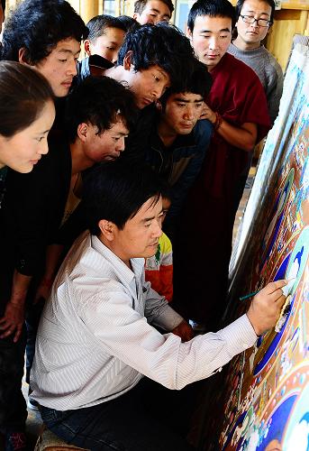 9月22日,在青海黃南藏族自治州,曲智(右下)在給學(xué)生們示范畫唐卡。新華社記者 張宏祥 攝