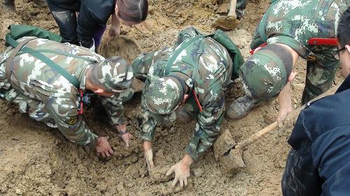 10月4日,武警昭通支隊(duì)官兵和駐地群眾一起在云南彝良山體滑坡現(xiàn)場(chǎng)挖掘被壓埋的人員。新華社發(fā)(李善明 攝)