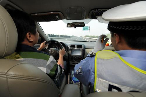 10月21日,杭州市高速交警第五大隊(duì)的一位交警(右)陪同一位從未上過(guò)高速行駛的駕駛員進(jìn)行駕駛體驗(yàn)。新華社記者 鞠煥宗 攝