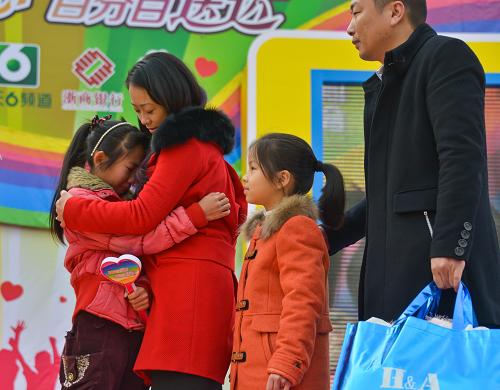 11月24日,來(lái)自浙江慶元縣山區(qū)的小學(xué)六年級(jí)學(xué)生劉薇(左一)在活動(dòng)現(xiàn)場(chǎng)和結(jié)對(duì)的愛(ài)心人士擁抱。她從小失去母親,現(xiàn)在父親也臥病在床,杭州一戶(hù)愛(ài)心家庭與她結(jié)對(duì),負(fù)擔(dān)起以后她所有的學(xué)習(xí)、生活費(fèi)用。新華社記者 徐昱 攝