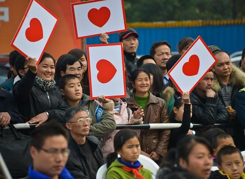 11月24日,市民手舉愛(ài)心標(biāo)牌參加助學(xué)結(jié)對(duì)活動(dòng)。新華社記者 徐昱 攝