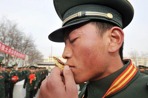 11月24日,在武警寧夏總隊(duì)直屬支隊(duì)的營地內(nèi),一位退伍老兵親吻自己帽檐上卸下的警徽。新華社記者 彭昭之 攝