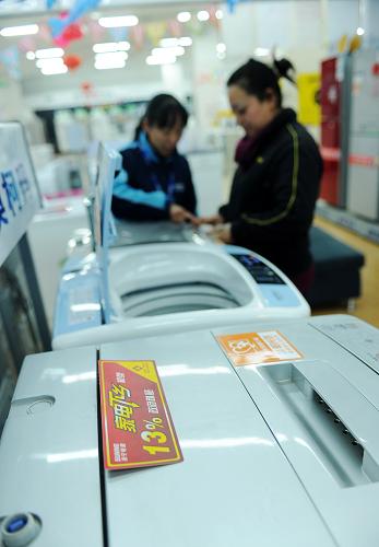 12月24日,在河北石家莊一家家電賣場(chǎng)內(nèi),顧客在選購(gòu)享受家電下鄉(xiāng)補(bǔ)貼的洗衣機(jī)。新華社發(fā) (朱旭東 攝)
