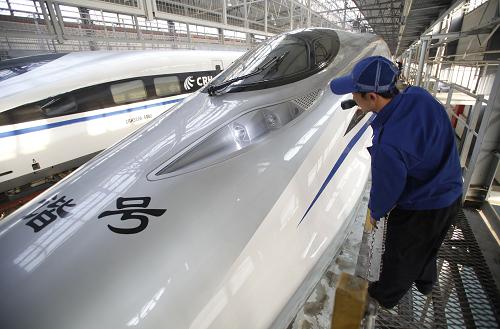 12月25日,在北京動(dòng)車段北京西動(dòng)車運(yùn)用所,地勤機(jī)械師在檢查車頭車燈。這輛車號(hào)為CRH380A-6120L的動(dòng)車組將運(yùn)行明天從北京西站開(kāi)出的G801次首列京廣高鐵。新華社記者 王申 攝
