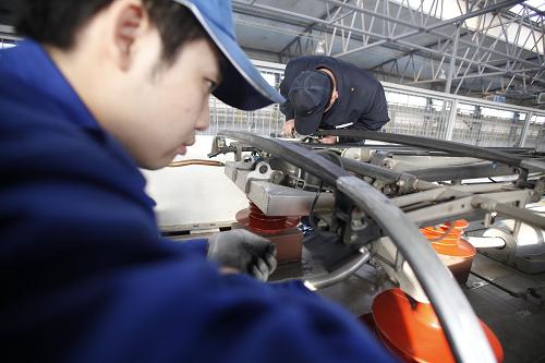 12月25日,在北京動(dòng)車段北京西動(dòng)車運(yùn)用所,地勤機(jī)械師在車頂檢查受電弓狀態(tài)。這輛車號(hào)為CRH380A-6120L的動(dòng)車組將運(yùn)行明天從北京西站開(kāi)出的G801次首列京廣高鐵。新華社記者 王申 攝