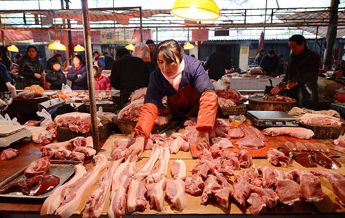 江西南昌市東湖區(qū)一家農貿市場攤主在擺放豬肉(12月22攝)。新華社記者 周科 攝