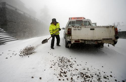 項(xiàng)青元在廬山北山積雪的路面鋪灑石子防滑(12月29攝)。新華社記者 周科 攝