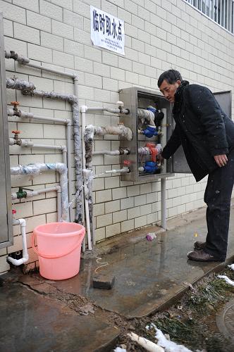 1月11日,家中水管凝凍無法取水的陽光小區(qū)住戶到臨時取水點接水。新華社發(fā)(陶亮 攝)