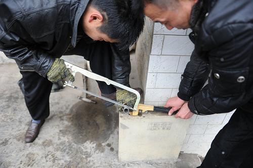 1月11日,威寧縣自來水公司維修搶險三分隊的工作人員在切鋸長度合適的更換水管。新華社發(fā)(陶亮 攝)