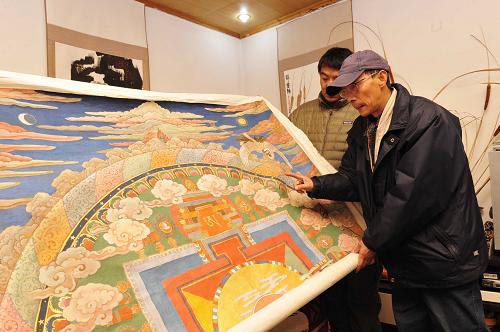 1月19日,西藏美術(shù)家協(xié)會(huì)主席韓書力為新唐卡畫作《扎西德勒》提出顏色修改意見(jiàn)。新華社發(fā)(劉坤 攝)