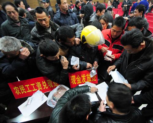2月3日,在江西省九江市聯(lián)合清理拖欠農(nóng)民工工資兌現(xiàn)大會現(xiàn)場,農(nóng)民工在領(lǐng)取兌現(xiàn)的工資。當(dāng)日是農(nóng)歷臘月廿三,民間俗稱“小年”,九江市舉行聯(lián)合清理拖欠農(nóng)民工工資兌現(xiàn)大會,確保農(nóng)民工領(lǐng)取足額工資返鄉(xiāng)過年。自2012年12月28日起,九江市有關(guān)部門聯(lián)合開展清理拖欠農(nóng)民工工資專項(xiàng)行動,共清欠農(nóng)民工工資標(biāo)的額5500余萬元,為6200余名農(nóng)民工追回被拖欠的工資。新華社發(fā)(胡國林 攝)