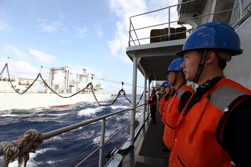 2月20日,綜合補給艦微山湖艦(左)在南海某海域為導彈驅(qū)逐艦哈爾濱艦實行液貨補給。新華社記者 饒饒 攝