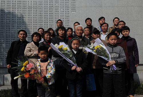 4月4日,阮定東(二排右四)帶領(lǐng)一家五代22口人在遇難者名單墻前合影。阮定東的爺爺阮家田的名字最近新刻在遇難者名單墻上。新華社記者 韓瑜慶 攝