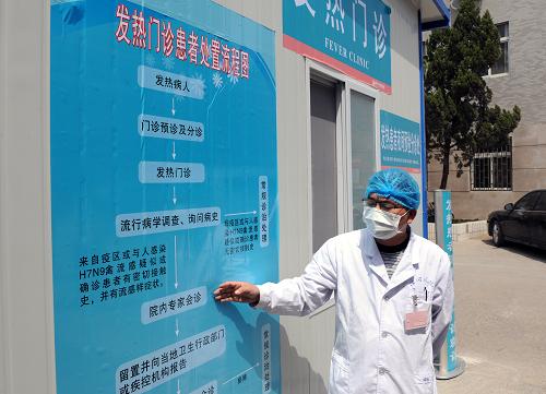 4月14日,河南省開(kāi)封市河南大學(xué)淮河醫(yī)院工作人員介紹發(fā)熱門(mén)診患者處置流程圖。新華社記者 李博 攝