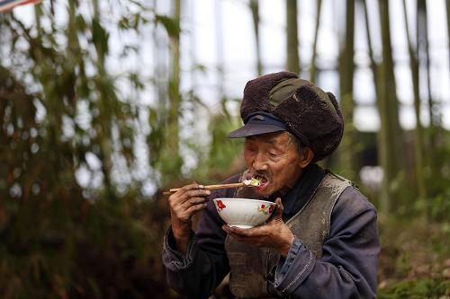 4月21日,蘆山縣太平鎮(zhèn)春光村溪口上組的一位老人在竹林帳篷里吃飯。新華社記者 白雪飛 攝