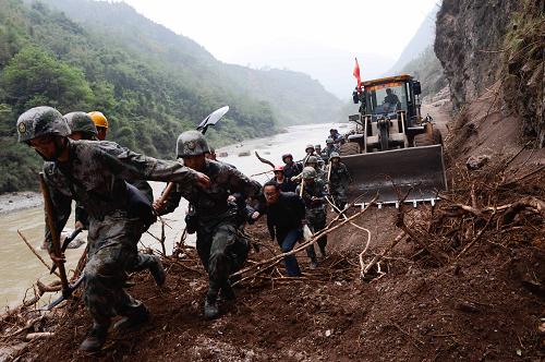4月21日,救援人員在武警水電部隊(duì)臨時(shí)開(kāi)辟的道路上通行。新華社記者 李橋橋 攝