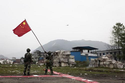 4月21日,兩名戰(zhàn)士在重災區(qū)四川省寶興縣靈關鎮(zhèn)揮舞國旗引導救援直升機。新華社發(fā)(毛健 攝)