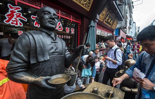 4月29日,在湖北省武漢市著名的小吃街戶(hù)部巷,游人等候品嘗蔡林記熱干面。 新華社記者 程敏 攝