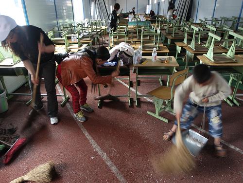 5月1日,雅安天全縣第一完全小學的學生、老師、家長齊上陣,清理板房教室內(nèi)外衛(wèi)生。新華社發(fā)(張曉理 攝)