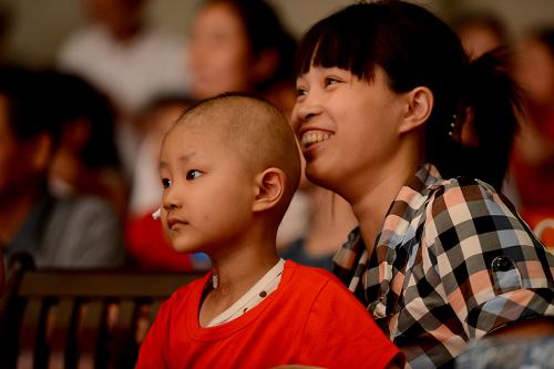 5月26日,一位白血病患兒和媽媽在聯(lián)誼會(huì)上觀看演出。新華社發(fā)(張端 攝)