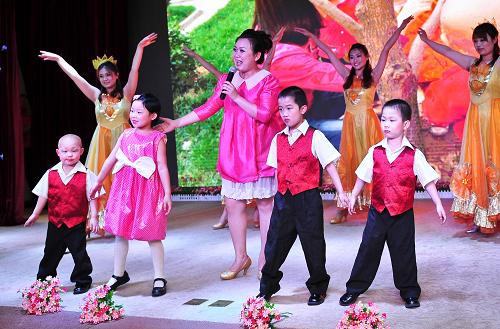 5月30日,天津市兒童福利院康復(fù)部幼兒園的老師和孩子們表演歌舞《愛(ài)在這里》。