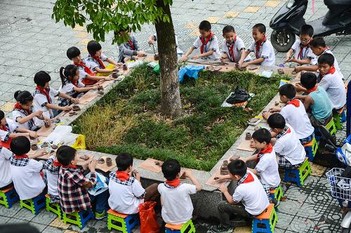 5月31日,芝村中心小學的孩子們在用泥巴捏出形態(tài)各異的趣味泥塑作品。當日,浙江省桐鄉(xiāng)市崇福鎮(zhèn)芝村中心小學舉行“泥巴文化節(jié)”,本次活動的主題是“染一身泥土氣 懷一個鄉(xiāng)土夢”,以“自畫像”、“幸福一家人”、“美麗的花瓶”等作為泥塑題目。讓孩子們在“玩泥巴”中感受泥土的芬芳、沾染泥土淳樸氣息。芝村中心小學是一所鄉(xiāng)村小學,1000多名孩子中有三分之一來自外地。學校以鄉(xiāng)土民俗文化作為特色教育,培養(yǎng)孩子們對泥塑、拼貼、剪紙等民俗手工藝的興趣,讓每個孩子都能從中找到快樂,健康成長。新華社記者 徐昱 攝