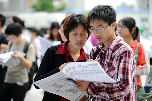 6月8日,一位高校畢業(yè)生求職者和家人一起查看招聘會(huì)提供的就業(yè)信息。新華社記者 鞠煥宗 攝