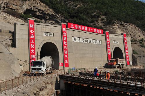 6月29日拍攝的南呂梁山隧道出口。當(dāng)日,我國西煤東運的黃金大通道、山西中南部鐵路通道全線最長的隧道——南呂梁山特長隧道安全貫通。該隧道的安全貫通,打通了控制全線鋪軌工期的咽喉,為確保明年5月全線接軌鋪通創(chuàng)造條件。南呂梁山特長隧道位于山西省臨汾市境內(nèi),由兩座各自長度為23.4公里的單線隧道組成,隧道集煤礦采空區(qū)、軟弱圍巖、地質(zhì)斷層和高瓦斯、突泥涌水等不良地質(zhì)為一體,施工技術(shù)難度為我國地下工程所罕見,被列為全線的首座特一級高風(fēng)險隧道。全長1267.3公里的山西中南部鐵路通道連接山西、河南和山東三省,投資超過1000億元,設(shè)計行車時速120公里,年貨運量達(dá)2億噸,預(yù)計2014年年底建成通車。新華社記者 杜華舉 攝