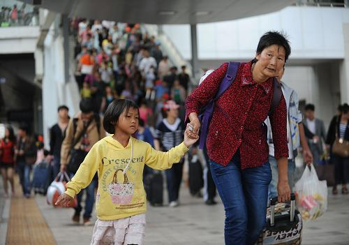7月6日,旅客們?cè)诶ッ骰疖囌具M(jìn)站乘車。新華社記者 秦朗 攝