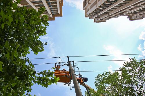 7月9日,國家電網浙江金華供電公司的搶修人員冒著高溫在金華市區(qū)李漁路帶電更換導線引線。新華社發(fā)(王平 攝)