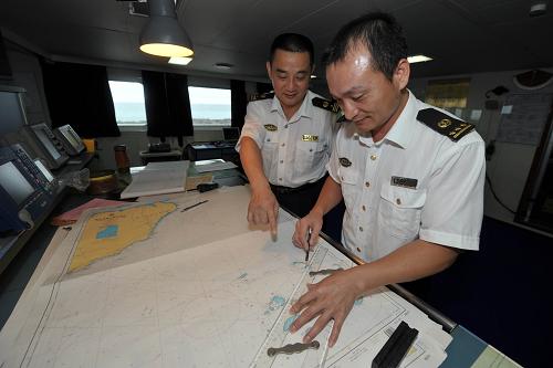 7月22日,海事執(zhí)法人員在“海巡21”船上工作。新華社記者 趙穎全 攝