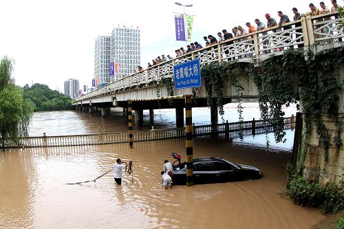 7月22日,人們在廣元街頭打撈被淹車輛。新華社發(fā)(高志農(nóng) 攝)