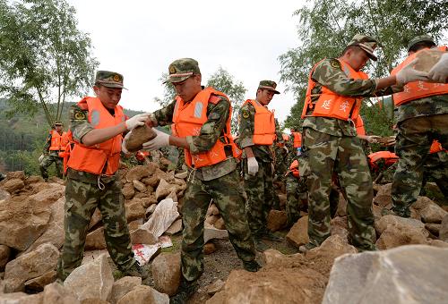 7月26日,武警延安支隊(duì)三中隊(duì)的官兵在延安勝利水庫排洪溝處搶險(xiǎn)。新華社記者 李一博 攝