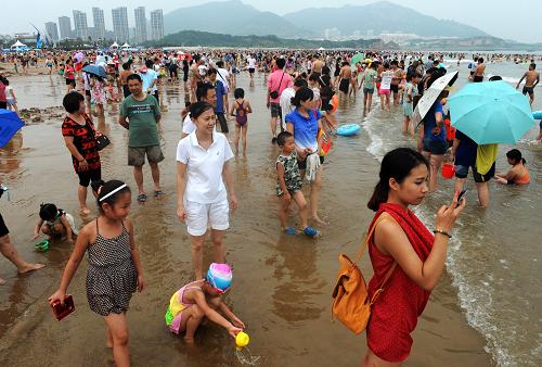7月28日,游客在青島石老人海水浴場游玩,海灘上未見到滸苔蹤跡。近日,影響青島沿海一線的滸苔綠藻逐漸減少,部分海水浴場開始恢復原本的面貌。據(jù)青島市滸苔應急處置指揮部介紹,當水溫升高至23攝氏度,滸苔生長活力便受到抑制,顏色也由綠色轉為黃白色,隨著水溫持續(xù)上升,滸苔也將“銷聲匿跡”。新華社記者 李紫恒 攝
