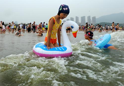 7月28日,兩名小女孩在青島石老人海水浴場戲水游玩,海邊未見到滸苔蹤跡。新華社記者 李紫恒 攝