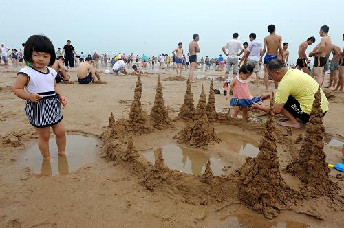 7月28日,游客在青島石老人海水浴場游玩,海灘上未見到滸苔蹤跡。新華社記者 李紫恒 攝
