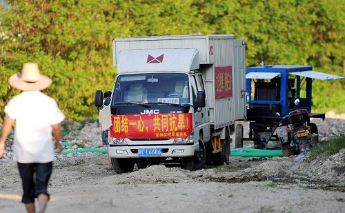 江西宜春市袁州區(qū)抗旱服務(wù)隊將抗旱發(fā)電機開進白馬村附近的南廟河幫助當(dāng)?shù)卮迕癯樗喔龋?月8日攝)。新華社記者 周科 攝