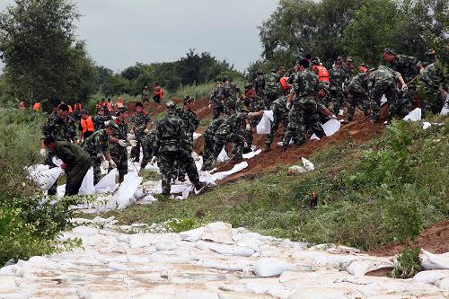 8月13日,邊防官兵在黑河市遜克縣干岔子鄉(xiāng)河西村處置管涌險(xiǎn)情,防止?jié)⒌?。新華社發(fā)(呂濤 攝)